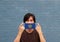 A man and hygienic mask with Nebraska flag pattern in his hand and raises it to cover his face. A mask is a very good protection