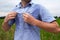 Man with hyperhidrosis sweating very badly under armpit in blue shirt, on grey