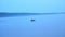 Man in an inflatable boat floats on the big lake, the view from the side