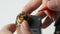 A man inserts new iron coil into a brown electronic cigarette