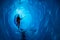 Man inside a melting glacier ice cave. Cut by water from the melting glacier, the cave runs deep into the ice of the Matanuska