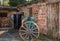 Man inspects an old wooden wheel.