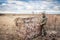 Man installing hunting tent in rural field