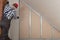 Man installing plasterboard sheet to wall for attic room construction