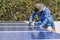 man installing solar panels on a home rooftop for alternative energy photovoltaic safe energy. power from nature sun power solar