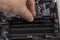 Man installs an DDR 4 DIMM 16 Gb Kingston HyperX Fury Memory RAM Module in the slot on the motherboard closeup