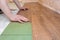 Man installs a laminated wooden floor. Repair concept