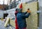 A man installs a layer of thermal insulation on the wall of the stairs outside - using mineral wool panels.