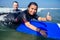 Man instructor and indian woman showing thumbs up in surf class in Goa sea