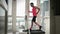 Man is intense training and running on treadmill at home in balcony. Young muscular male is exercising on home smart trainer, watc