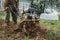 A man intensively plows his vegetable garden motor cultivator