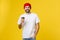 Man on isolated vibrant yellow color taking a coffee in takeaway paper cup and smiling because he will start the day