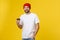 Man on isolated vibrant yellow color taking a coffee in takeaway paper cup and smiling because he will start the day