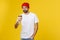 Man on isolated vibrant yellow color taking a coffee in takeaway paper cup and smiling because he will start the day