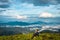 Man isolated watching the serene nature at hill top with amazing cloud layers in background