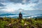 Man isolated watching the serene nature at hill top with amazing cloud layers in background