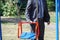 A man in a jacket and tie, an official, businessman or contractor, checks the safety and strength of a new children`s swing