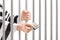 Man in jail holding prison bars and giving bribe