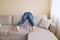 Man in jeans is cleaning behind sofa