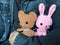 Man in jeans jacket holding cute brown teddy bear and pink bunny crochet dolls