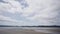 man jogging along the large beach of new chums beach, new zealand