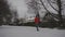 Man jogging on snowy path through park in city listening to music in earphones in winter in Germany. Athletic man