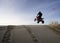 Man jumping his quad over a sand dune