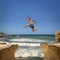 Man jumping over the abyss between two rocky mountains.