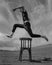 Man jumping over chair in desert