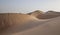 Man in kandura in a desert resting