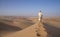 Man in kandura in a desert at sunrise