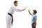 Man in karate kimono gesturing high-five with a child