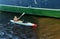 Man in a kayak floats next to the side of the ship