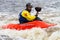 Man in a kayak with paddle in white water