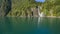 Man in kayak paddling towards the waterfall