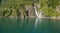 Man in kayak paddling towards the waterfall