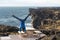 Man keep balance standing on his hands on Sea scape with dangerous vertical cliff background, cloudscape during sunset