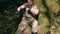 A man in a khaki uniform is resting in the forest under a tree