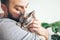 Man is kissing and cuddling his sweet and cute looking Devon Rex cat. Kitten feels happy to be with its owner.  Kitty sits in