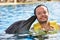 Man kissing dolphin in pool