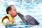 Man kissing dolphin in pool