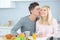 Man kissing lady at breakfast table