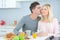 Man kissing partner at breakfast table