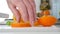 Man in the kitchen cut for salad orange fruit in fresh sweet and flavored slices