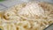 A Man in the Kitchen Prepares a Tray with Macaroni and Grate Cheese