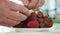 Man in the Kitchen Selecting and Cleaning Strawberry Fruits on a Plate