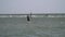 A man kitesurfing, flying in from the sky and lands on the water