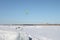 Man is kiting on skis on the frozen river