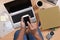 Man kneeling on the floor working from home with his laptop Cell Phone, Books, Coffee and other items to telecommute during the