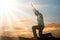 Man Kneeling And Praying At Sunset